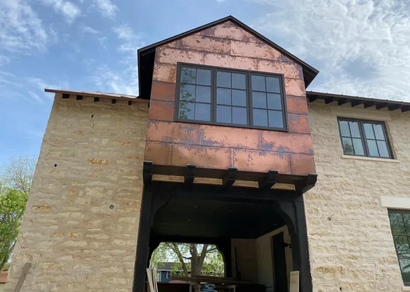 Copper metal panel facade on a stone building for Roof Repair in Merrill