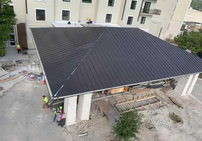 Metal roofing installation team working on a commercial building in Merrill